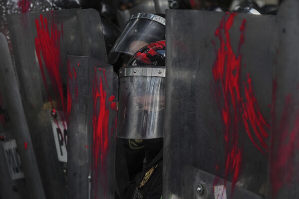 Un policía mira detrás de escudos que fueron rociados con pintura por manifestantes durante una protesta contra la guerra en la Franja de Gaza, en la Ciudad de México.  - Sputnik Mundo