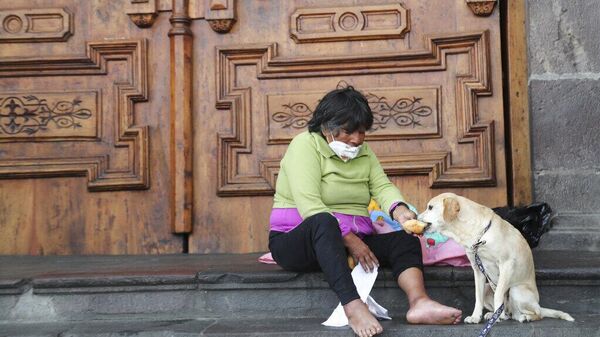 Una mujer sin hogar comparte un trozo de pan con su perro en Quito, Ecuador, el 8 de mayo de 2021  - Sputnik Mundo