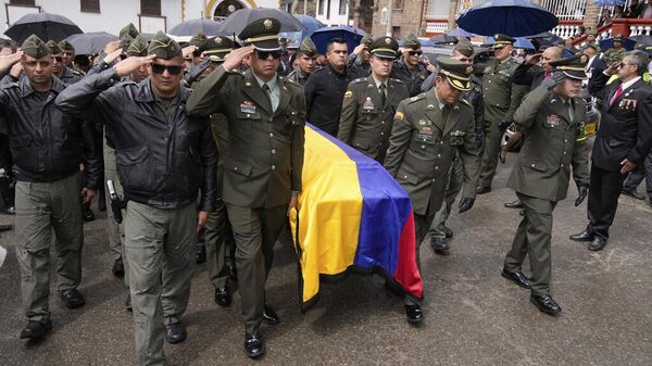 Agentes de la policía cargan el féretro del capitán Francisco Merchán, piloto que falleció cuando su helicóptero fue derribado por un disidente de una facción de la antigua guerrilla de las FARC Agentes de la policía cargan el féretro del capitán Francisco Merchán, piloto que falleció cuando su helicóptero fue derribado por un disidente de una facción de la antigua guerrilla de las FARC - Sputnik Mundo