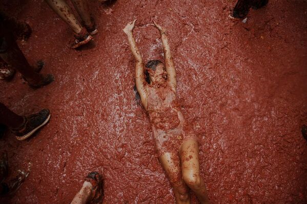 Una participante durante la fiesta anual de La Tomatina, en el municipio valenciano de Buñol, España.La feria se celebró por la 78.ª vez el pasado 27 de agosto. Más de 20.000 personas lanzaron un total de 120 toneladas de tomates no aptos para el consumo. - Sputnik Mundo