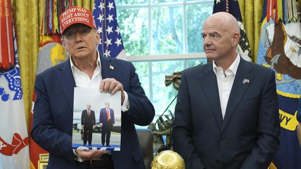 Президент США Дональд Трамп с фотографией президента России Владимира Путина и президент ФИФА Джанни Инфантино в Овальном кабинете Белого дома в Вашингтоне - Sputnik Mundo