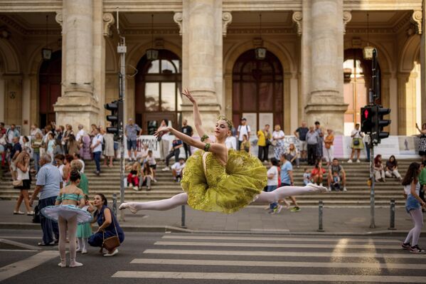 La bailarina de 15 años, Daria Toma, del Estudio de Ballet de la Ópera Nacional de Rumania, baila frente al Museo Nacional de Historia de Rumania durante la Noche de la Danza, un evento en el que se exhiben una gran variedad de estilos de baile en la avenida Calea Victoriei de la capital, Bucarest. - Sputnik Mundo
