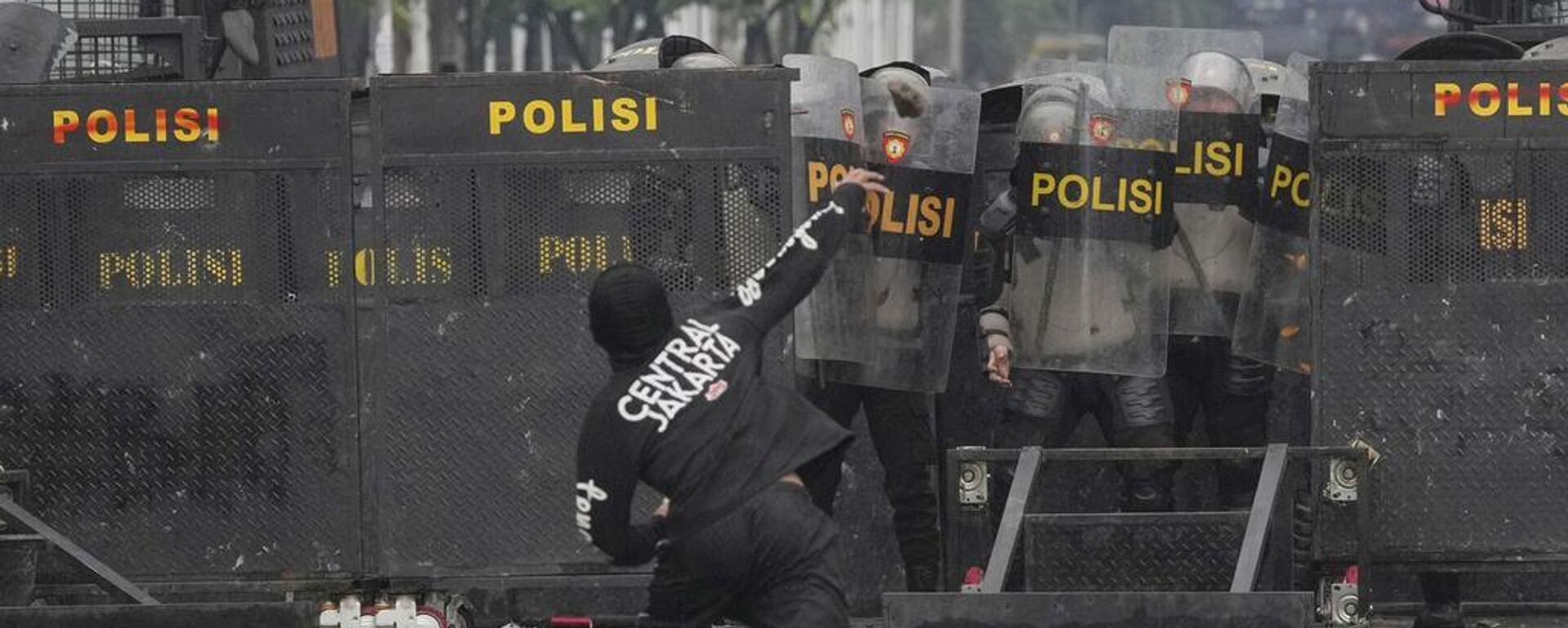 Agentes de Policía se cubren con escudos antidisturbios mientras un manifestante les arroja piedras durante una protesta contra las generosas asignaciones otorgadas a los miembros del Parlamento, frente al Parlamento en Yakarta, Indonesia, el 31 de agosto, 2025 - Sputnik Mundo, 1920, 31.08.2025