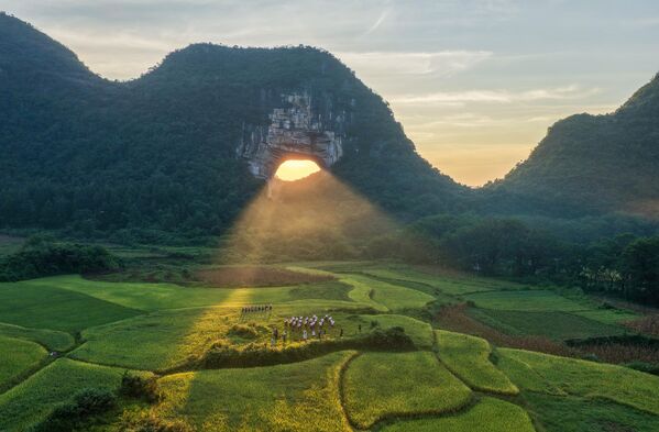 Un agujero en la roca, o tiankeng (literalmente: pozo celestial), en el área escénica de la ciudad china de Yueyang, famoso por su típico paisaje kárstico y el efecto Tyndall creado por la luz del sol que pasa a través de la cueva. - Sputnik Mundo