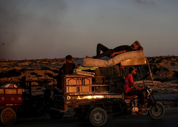 Los palestinos avanzan hacia el centro de Gaza por la calle Al Rashid en vehículos, carros tirados por caballos y a pie con sus escasas pertenencias. Esto sucede por los intensificados ataques israelíes en el norte de Gaza, que los obligan a huir. - Sputnik Mundo