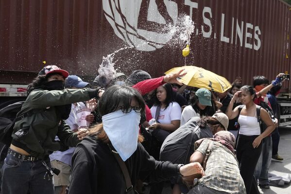 Los manifestantes lanzan globos llenos de agua sucia durante una protesta frente al Departamento de Obras Públicas y Carreteras de Filipinas. Los ciudadanos denuncian la corrupción generalizada en los proyectos de control de inundaciones, que podrían implicar a funcionarios de obras públicas e ingenieros, empresas de construcción y políticos en un escándalo que ha provocado indignación pública, en Manila, Filipinas. - Sputnik Mundo