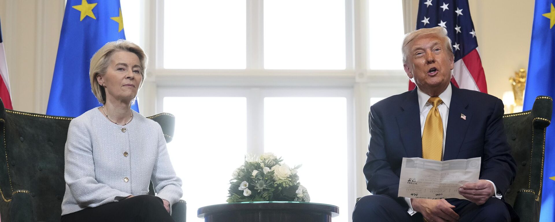  President Donald Trump reads from a paper and European Commission President Ursula von der Leyen listens after reaching a trade deal between the U.S. and the EU at the Trump Turnberry golf course in Turnberry, Scotland Sunday, July 27, 2025.  - Sputnik Mundo, 1920, 15.01.2026