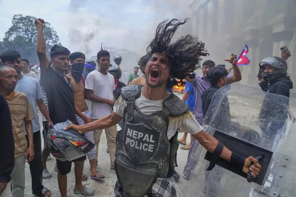 Un manifestante con chaleco antibalas y un escudo arrebatado a un policía grita consignas en el palacio de Singha Durbar, sede de varios Ministerios y oficinas del Gobierno de Nepal, durante una protesta contra la prohibición de las redes sociales y la corrupción en la capital, Katmandú. Un manifestante con chaleco antibalas y un escudo arrebatado a un policía grita consignas en el palacio de Singha Durbar, sede de varios Ministerios y oficinas del Gobierno de Nepal, durante una protesta contra la prohibición de las redes sociales y la corrupción en la capital, Katmandú. - Sputnik Mundo