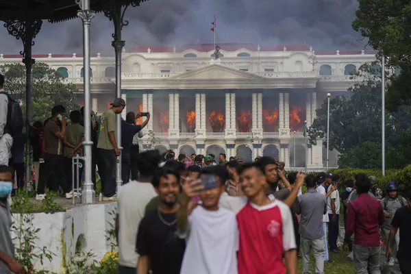 Los manifestantes se hacen selfies y celebran en el palacio de Singha Durbar, después de que fuera incendiado durante protestas contra la prohibición de las redes sociales y la corrupción en Nepal. Los manifestantes se hacen selfies y celebran en el palacio de Singha Durbar, después de que fuera incendiado durante protestas contra la prohibición de las redes sociales y la corrupción en Nepal. - Sputnik Mundo