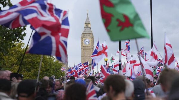 Los manifestantes participan en la marcha y manifestación Unite the Kingdom, liderada por Tommy Robinson, cerca de Westminster, Londres, 13 de septiembre de 2025 - Sputnik Mundo