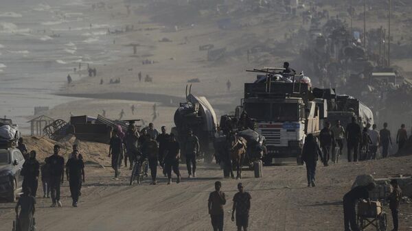 Los palestinos desplazados huyen de la ciudad de Gaza a pie y en vehículos, llevando sus pertenencias por la carretera costera hacia el sur de Gaza - Sputnik Mundo