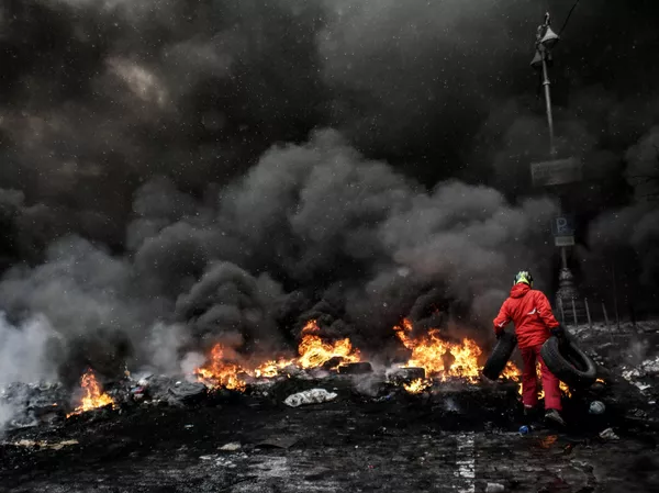 Un manifestante echa leña al fuego en la plaza Maidán de Kiev, Ucrania, el 22 de enero de 2014. - Sputnik Mundo