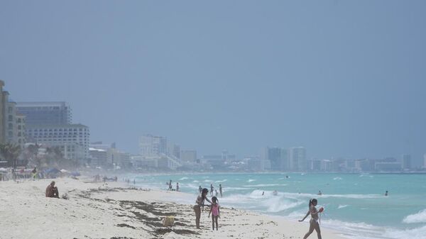 Turistas descansan en la playa de Cancún, México (imagen referencial) - Sputnik Mundo