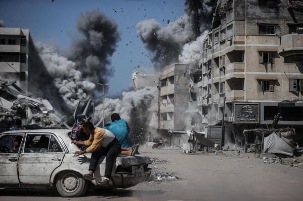 Residentes abandonan la zona atacada por las fuerzas israelíes en Gaza. - Sputnik Mundo