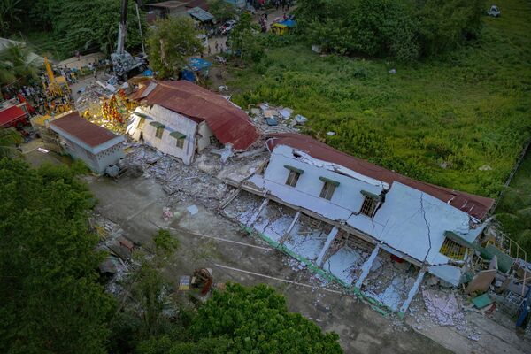 Los equipos de rescate buscan sobrevivientes bajo los escombros de un edificio residencial que se derrumbó el 1 de octubre de 2025 en la ciudad de Bogo, Filipinas. - Sputnik Mundo