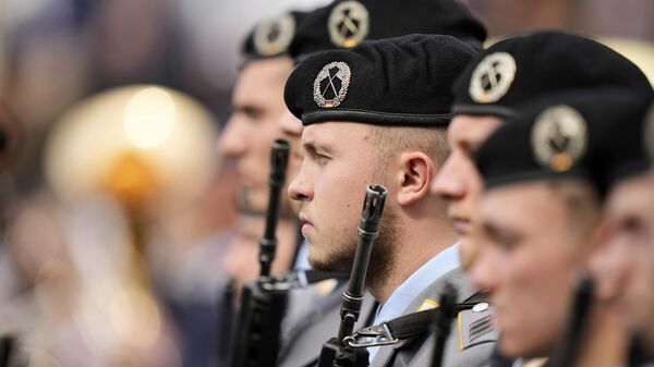 Soldados observan a los nuevos reclutas del ejército alemán Bundeswehr asistir a una ceremonia para tomar juramento - Sputnik Mundo