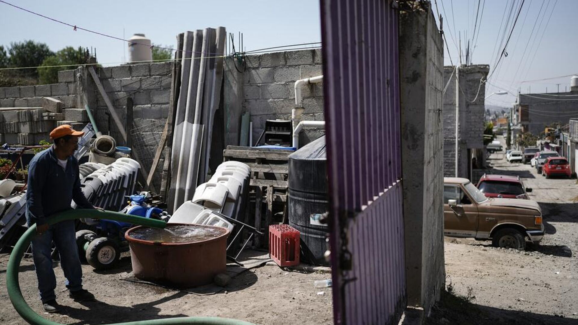 Un trabajador entrega agua a una vivienda en Iztapalapa, a las afueras de la Ciudad de México, el miércoles 6 de marzo de 2024. La extensa Ciudad de México obtiene su agua de acuíferos subterráneos sobreexplotados y de una vasta red de canales, presas y embalses llamada el Sistema Cutzamala. (Foto AP/Eduardo Verdugo) - Sputnik Mundo, 1920, 11.10.2025