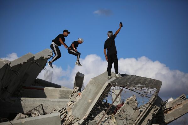 Jóvenes atletas palestinos realizan movimientos de parkour entre las ruinas de edificios destruidos en el área de al Mughraqa, luego del alto el fuego en la ciudad de Gaza. Los atletas usan su deporte para llamar la atención sobre la destrucción causada por los ataques israelíes, mostrando habilidades acrobáticas entre los escombros. - Sputnik Mundo