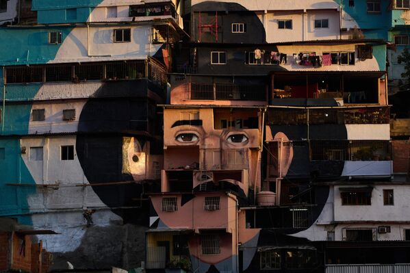 Las fachadas de las casas están blasonadas con una imagen del médico José Gregorio Hernández en el barrio de Petare en Caracas, Venezuela. Venerado por millones como el médico de los pobres, Hernández será el primer santo de Venezuela después de que el Papa Francisco aprobara un decreto en febrero. - Sputnik Mundo