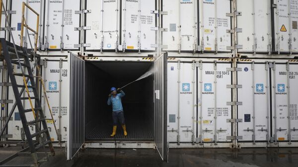 Un empleado lava contenedores para la exportación de diversos productos en el Puerto de Santa Marta, Colombia Un empleado lava contenedores para la exportación de diversos productos en el Puerto de Santa Marta, Colombia - Sputnik Mundo
