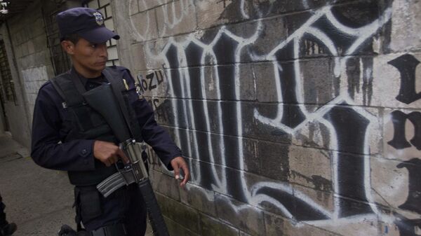 Un miembro de la Policía Nacional de El Salvador camina junto al símbolo de la pandilla Mara Salvatrucha pintado en una pared durante un operativo antipandillas en San Salvador, El Salvador (imagen referencial).  - Sputnik Mundo