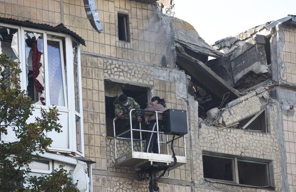 Un residente de una casa con un gato rescatado, después del bombardeo nocturno de las Fuerzas Armadas de Ucrania en Yasinovátaya, república popular de Donetsk. - Sputnik Mundo