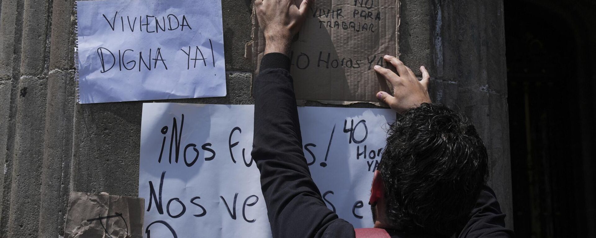 Un manifestante cuelga carteles contra la gentrificación afuera de una conferencia de prensa de la alcaldesa de la Ciudad de México, Clara Brugada, sobre la regulación de los precios de alquiler de viviendas en la sede del Gobierno de la ciudad, el miércoles 16 de julio de 2025.  - Sputnik Mundo, 1920, 26.10.2025