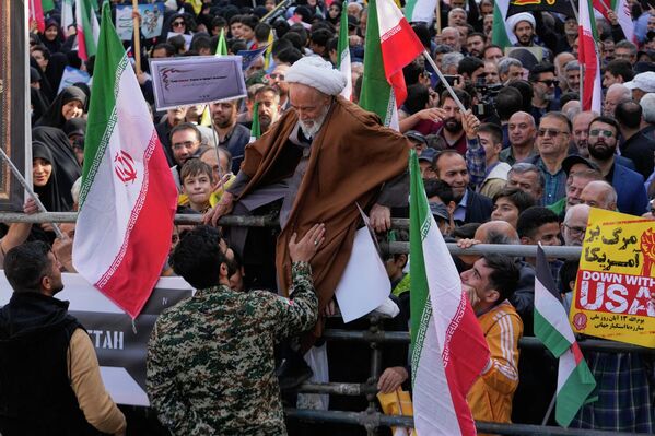 Un clérigo intenta atravesar unas barreras, durante la manifestación anual frente a la antigua Embajada de Estados Unidos en Teherán, conmemorando el aniversario de la toma del establecimiento en 1979. - Sputnik Mundo