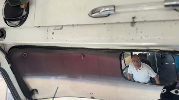 Juan Pablo Hernández Velasco, dueño y chofer de un microbús que se dedica al oficio desde hace 20 años, se observa en el espejo retrovisor de su unidad Juan Pablo Hernández Velasco, dueño y chofer de un microbús que se dedica al oficio desde hace 20 años, se observa en el espejo retrovisor de su unidad - Sputnik Mundo