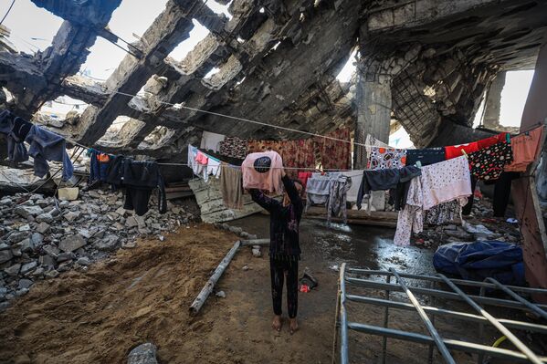 Los palestinos que viven entre los escombros de los edificios destruidos por los ataques de Israel, tras el alto al fuego y la retirada de las tropas israelíes de Gaza. - Sputnik Mundo