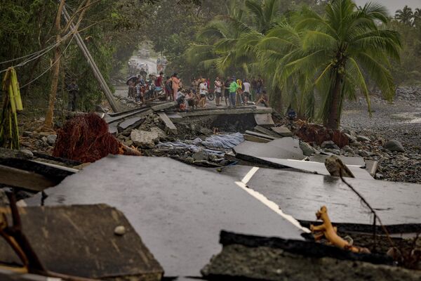 Un grupo de personas observa la carretera destruida por el tifón Fung Wong, Filipinas. - Sputnik Mundo