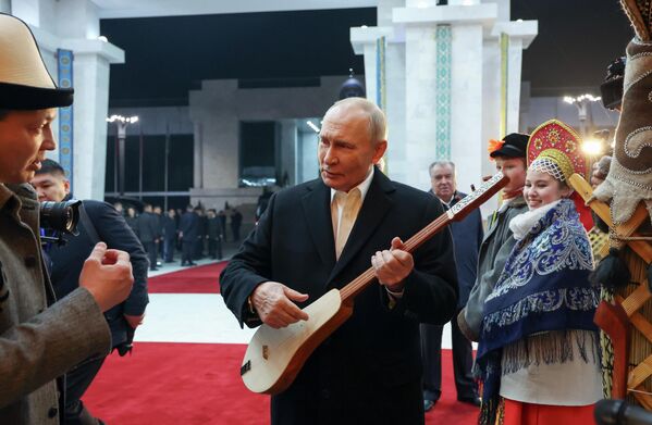 El presidente ruso, Vladímir Putin, sostiene el instrumento musical nacional kirguís komuz durante la reunión de los jefes de Estado miembros de la Organización del Tratado de Cooperación de Seguridad, celebrada en este país. - Sputnik Mundo