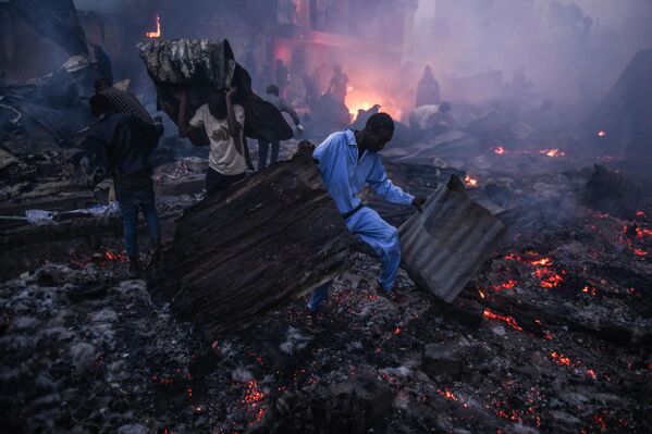 Personas combatiendo las consecuencias de un fuerte incendio en Nairobi, capital de Kenia. - Sputnik Mundo