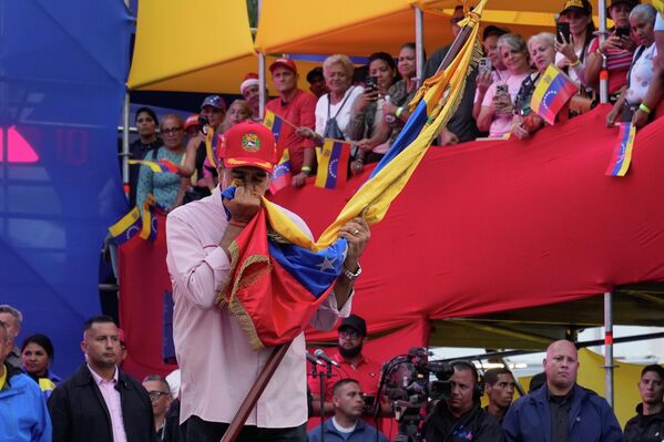 El presidente venezolano, Nicolás Maduro, besa la bandera nacional durante la ceremonia de juramento de los Comandos de Comunidades Bolivarianas. - Sputnik Mundo