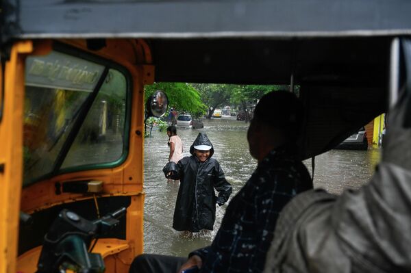 Un menor juega en una calle inundada tras las fuertes lluvias provocadas por el ciclón Ditwah, en la India. - Sputnik Mundo
