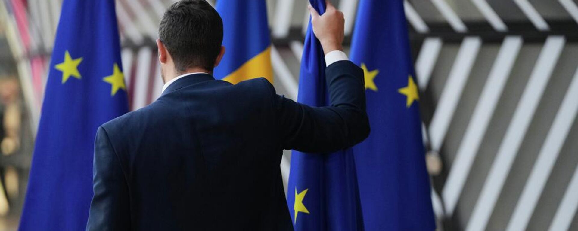 Una persona retira las banderas de la Unión Europea en Bruselas Una persona retira las banderas de la Unión Europea en Bruselas - Sputnik Mundo, 1920, 08.12.2025