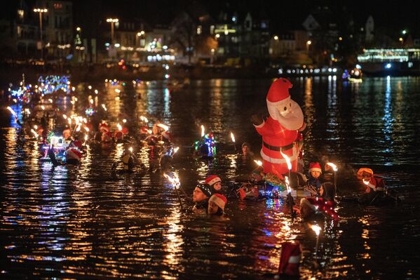 En vísperas del Día de San Nicolás, los participantes de natación bajaron el río Mosela con antorchas. Alrededor de 100 hombres y mujeres se adentraron en el río a las afueras de la ciudad de Bernkastel-Kues y nadaron hasta el casco antiguo, donde emergieron entre los aplausos de numerosos espectadores, Alemania. - Sputnik Mundo