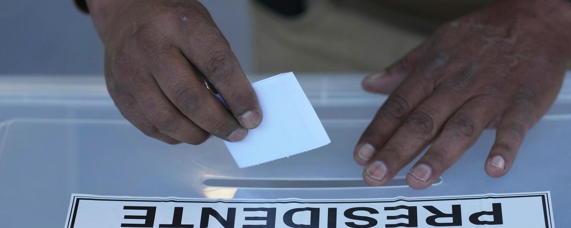 Una persona vota durante las elecciones generales en Santiago, Chile. - Sputnik Mundo, 1920, 14.12.2025