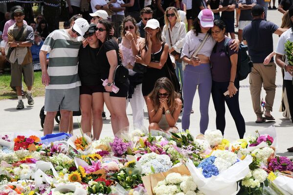 Las personas se reúnen alrededor de una corona de flores en memoria de las víctimas del tiroteo de Bondi Beach, Sídney.  - Sputnik Mundo