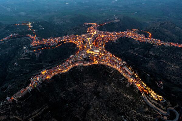 Una fotografía aérea tomada al atardecer muestra la comuna italiana de Centuripe, situada a más de 700 metros sobre el nivel del mar y frente al volcán Etna. Su singular trazado urbano se asemeja a una figura humana reclinada o a una estrella de mar.   - Sputnik Mundo