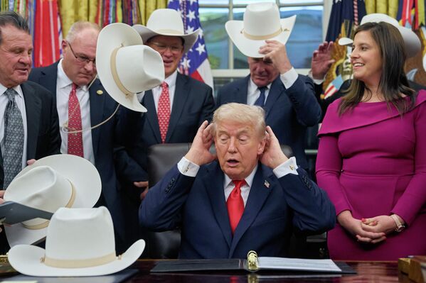 El presidente de EEUU, Donald Trump, se ajusta el cabello en tono de broma, mientras posa para una foto con miembros del equipo masculino de hockey olímpico de Estados Unidos de 1980, en la Oficina Oval de la Casa Blanca, en Washington D. C. - Sputnik Mundo