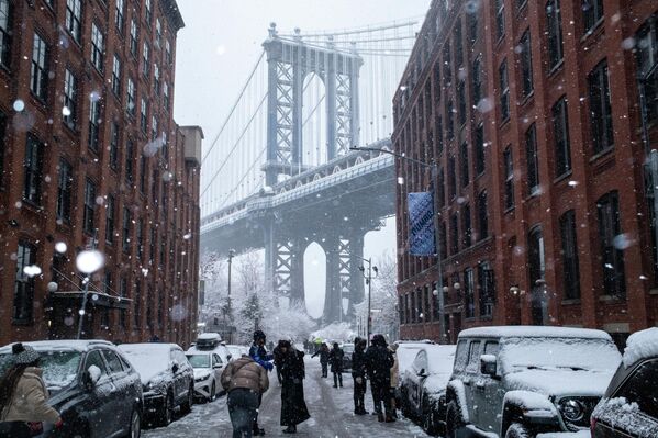 La gente se reúne en Washington Street, frente al puente de Manhattan, durante una nevada, en Brooklyn, Nueva York. - Sputnik Mundo