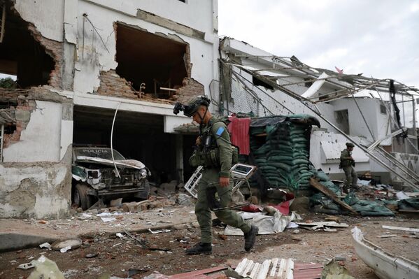 Agentes de seguridad caminan por una estación de policía destruida en un ataque, que el Gobierno atribuyó a disidentes de las Fuerzas Armadas Revolucionarias de Colombia (FARC), en Colombia. - Sputnik Mundo