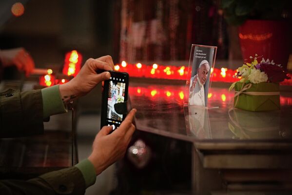 Una mujer toma una fotografía del difunto papa Francisco con la leyenda "Por favor, recuerden orar por mí" durante una misa en su memoria en la iglesia del Espíritu Santo en el Distrito Sajón, afuera del Vaticano, el 24 de abril de 2025. Una mujer toma una fotografía del difunto papa Francisco con la leyenda "Por favor, recuerden orar por mí" durante una misa en su memoria en la iglesia del Espíritu Santo en el Distrito Sajón, afuera del Vaticano, el 24 de abril de 2025. - Sputnik Mundo