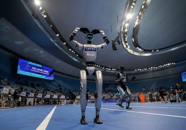 Un robot humanoide gesticula antes de una carrera durante una demostración previa a la ceremonia de apertura de los Juegos Mundiales de Robots Humanoides en el Óvalo Nacional de Patinaje de Velocidad en Pekín, el 14 de agosto de 2025. China albergó el evento del 14 al 17 de agosto de 2025 y se considera el primero de su tipo. Un robot humanoide gesticula antes de una carrera durante una demostración previa a la ceremonia de apertura de los Juegos Mundiales de Robots Humanoides en el Óvalo Nacional de Patinaje de Velocidad en Pekín, el 14 de agosto de 2025. China albergó el evento del 14 al 17 de agosto de 2025 y se considera el primero de su tipo. - Sputnik Mundo