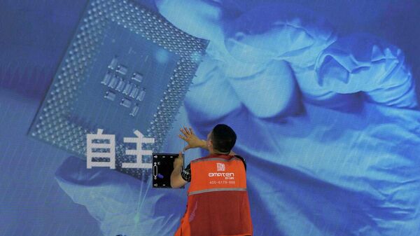 Un trabajador revisa el panel de visualización que muestra un chip de computadora en China - Sputnik Mundo