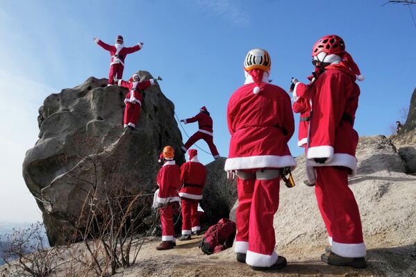 Montañistas vestidos de Papá Noel posan durante un evento para rezar por ascensos seguros en el año nuevo 2026, en un monte del parque nacional Bukhansan, en Seúl, Corea del Sur. - Sputnik Mundo