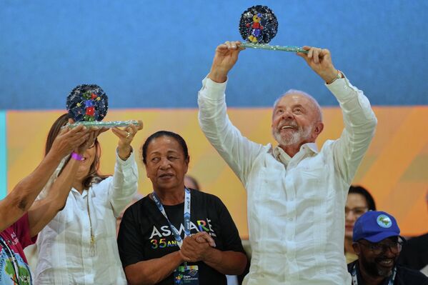 El presidente brasileño, Luiz Inacio Lula da Silva, levanta un obsequio que recibió durante un acto navideño con las familias de los recolectores de residuos reciclables en Sao Paulo. - Sputnik Mundo