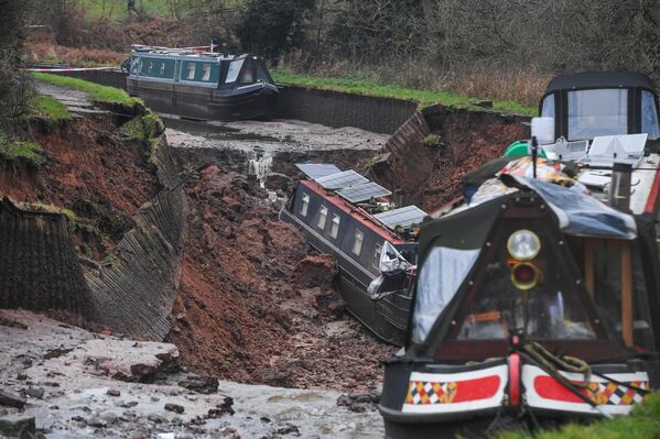 La escena en la villa de Whitchurch en Shropshire, Reino Unido, donde los servicios de emergencia declararon un incidente grave, tras recibir informes sobre un socavón que provocó la salida de grandes volúmenes de agua hacia tierra.Diez personas fueron puestas a salvo, después de que un hundimiento, de unos 50 metros de longitud, rompiera un canal en Shropshire, dejando varias embarcaciones varadas. - Sputnik Mundo