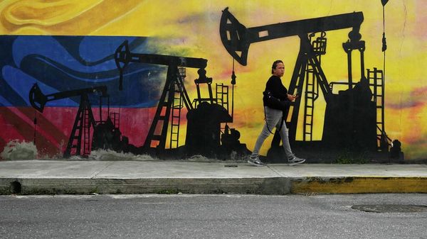 Un lugareño pasa junto a un mural que representa bombas de petróleo y pozos en Caracas - Sputnik Mundo